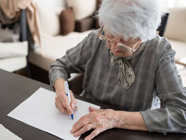 photo of a senior woman doing an Alzheimer's disease cognitive function self-assessment test at home